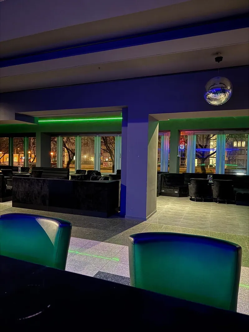 Barhocker, Sitzgruppen und Discokugel der Kontrast-Bar
