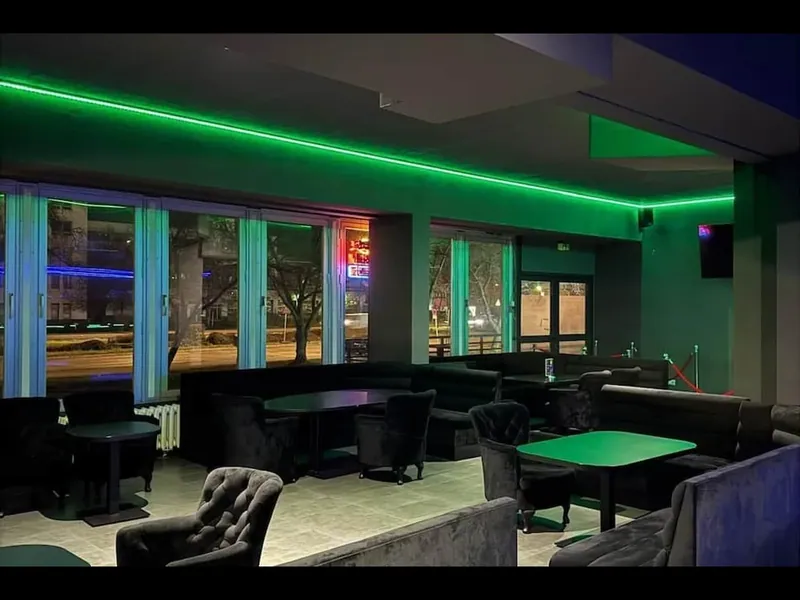 Kontrast Bar mit Sesseln und grüner Lichtinstallation